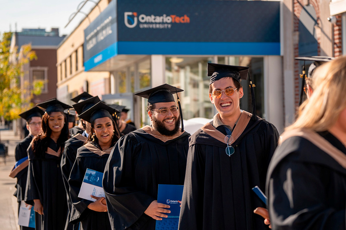 Students in convocation attire outside the Regent Theatre