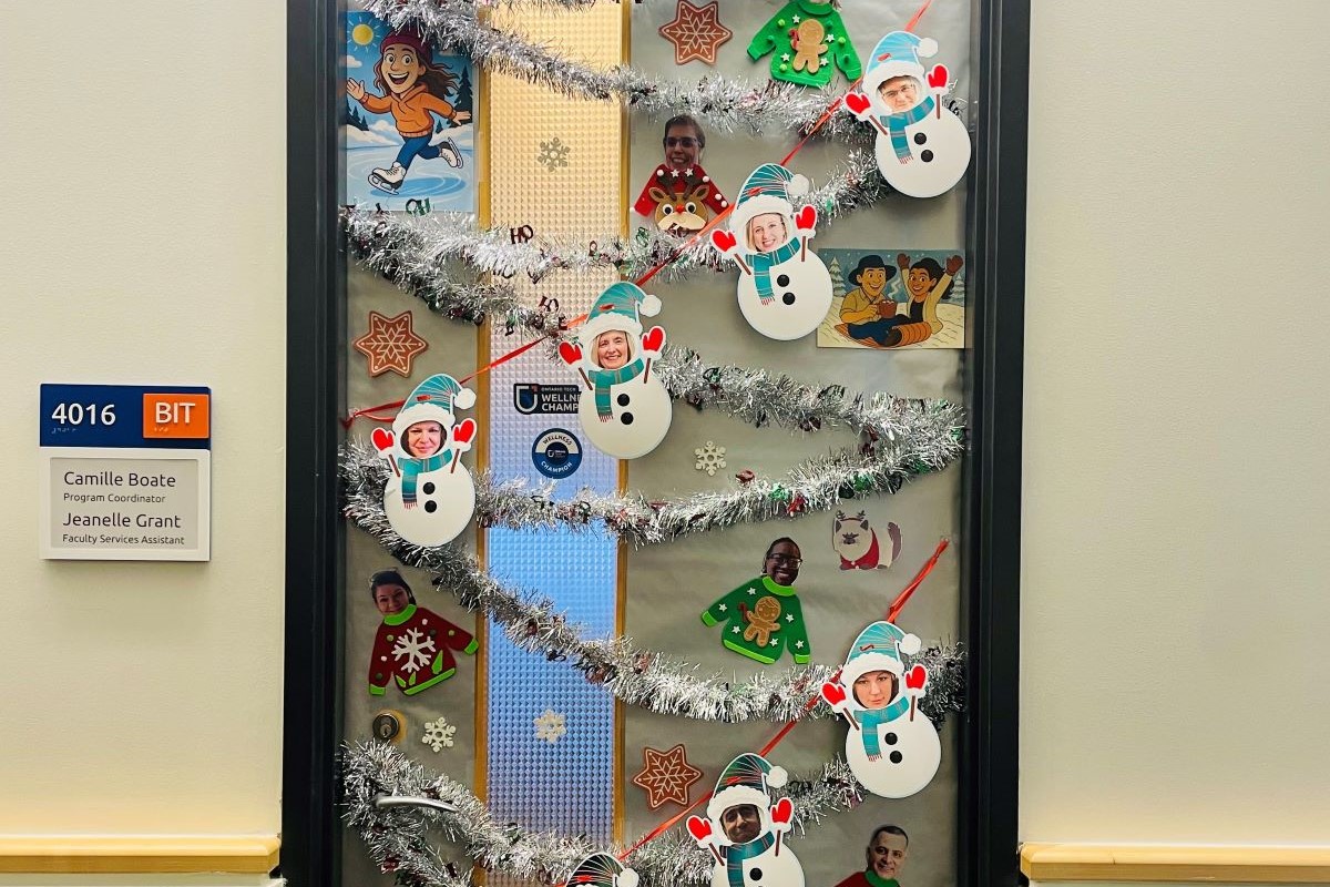 Office door decorated with tinsel and snowman.