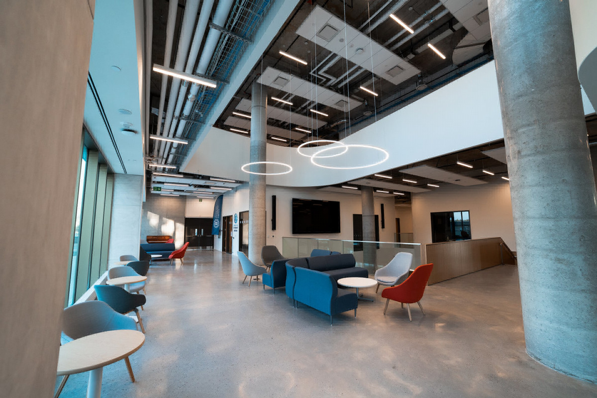 Interior view of Shawenjigewining Hall at Ontario Tech University, showing bright modern study spaces and hallways where students collaborate and move between classes.